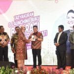 R.A. Anita Noeringhati menyerahkan buku ke Herman Deru.