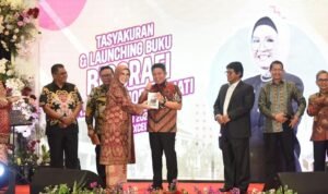 R.A. Anita Noeringhati menyerahkan buku ke Herman Deru.