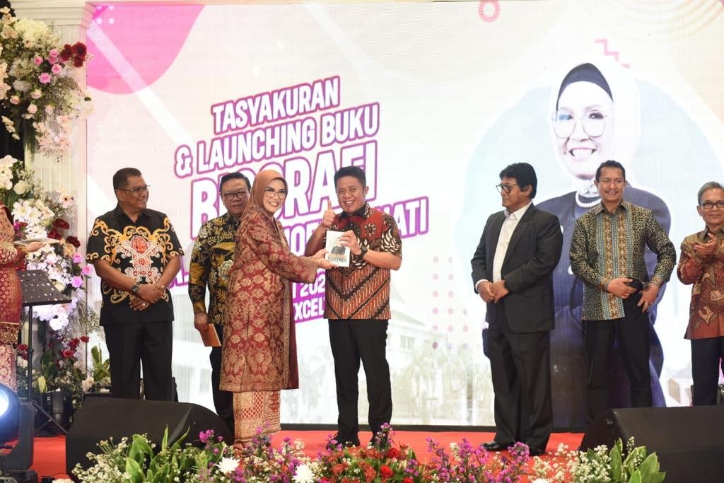 R.A. Anita Noeringhati menyerahkan buku ke Herman Deru.